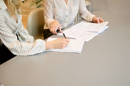 dos mujeres firmando un contrato