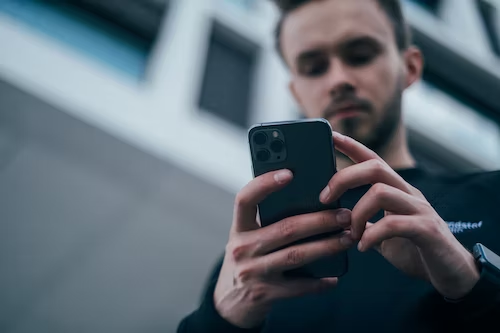 Hombre blanco utilizando un celular para realizar autenticación digital